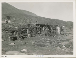 Image of Typical West Greenland home, Rock and Sod home. Miriam walking in back